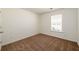 This cozy bedroom features plush brown carpeting and a bright window with a street view at 4940 Elm Brook Dr, Atlanta, GA 30349