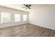Bright bedroom featuring wood-look floors, a ceiling fan, and large windows with blinds for plenty of natural light at 4940 Elm Brook Dr, Atlanta, GA 30349