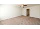 Empty bedroom offers neutral paint and carpet, a ceiling fan, and a hallway door at 4940 Elm Brook Dr, Atlanta, GA 30349