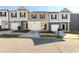 Street view of townhomes with garages and well-maintained lawns on a sunny day at 4940 Elm Brook Dr, Atlanta, GA 30349