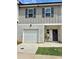 Inviting two-story home featuring a garage and a charming front entrance with decorative plants and a wreath at 4940 Elm Brook Dr, Atlanta, GA 30349