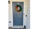 Close-up of a gray front door adorned with a wreath of flowers and greenery at 4940 Elm Brook Dr, Atlanta, GA 30349