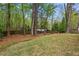An open backyard with grass and a wooded perimeter provides a private, natural setting at 1155 Moores Mill Nw Rd, Atlanta, GA 30327