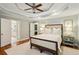 Spacious bedroom with hardwood floors, tray ceilings, ceiling fan, and doorway to ensuite bathroom at 1155 Moores Mill Nw Rd, Atlanta, GA 30327