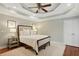 Comfortable bedroom features tray ceilings, a ceiling fan, and natural light at 1155 Moores Mill Nw Rd, Atlanta, GA 30327