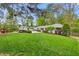 Scenic view of ranch home featuring a lush green lawn, mature trees, and manicured landscaping at 1155 Moores Mill Nw Rd, Atlanta, GA 30327