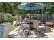 An outdoor patio with a table, seating, and an umbrella surrounded by lush landscaping at 1187 Druid Walk, Decatur, GA 30033