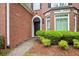 Close-up of the home's front entrance, showcasing a black door, brick facade, and green shrubbery at 1187 Druid Walk, Decatur, GA 30033