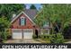 Charming brick home featuring a two-car garage, arched window, and well-maintained landscaping at 1187 Druid Walk, Decatur, GA 30033