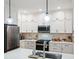 Well-lit kitchen showcasing white cabinetry, a stainless steel microwave, and modern pendant lighting at 1187 Druid Walk, Decatur, GA 30033