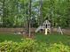 Wooded backyard with a fun playhouse, slide, and swing set for  at 230 Pebble Trl, Alpharetta, GA 30009