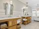 Bathroom featuring double sinks, stylish mirrors, and wooden cabinets at 230 Pebble Trl, Alpharetta, GA 30009