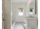 Elegant bathroom features a marble countertop, modern fixtures, and a beautifully tiled shower with flower patterned tile floor at 230 Pebble Trl, Alpharetta, GA 30009