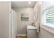 Bright bathroom with a stylish vanity, patterned shower curtain, and a window for natural light at 230 Pebble Trl, Alpharetta, GA 30009