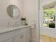 Stylish powder bathroom with marble countertop, decorative mirror, and natural light at 230 Pebble Trl, Alpharetta, GA 30009