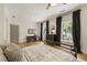 Stylish bedroom featuring hardwood floors, a dark metal bed, and a black-and-white patterned curtain at 230 Pebble Trl, Alpharetta, GA 30009