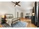 Modern bedroom with a ceiling fan, hardwood floors, a dark metal bed, and a work space at 230 Pebble Trl, Alpharetta, GA 30009