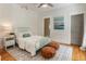 Cozy bedroom with light blue metal frame bed, hardwood floors, and decorative brown leather poufs at 230 Pebble Trl, Alpharetta, GA 30009