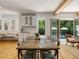 Bright dining room with wood floors, rustic table, and views of the pool at 230 Pebble Trl, Alpharetta, GA 30009