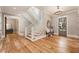 Bright foyer features hardwood floors, a staircase with white railings, and elegant lighting fixtures at 230 Pebble Trl, Alpharetta, GA 30009