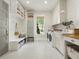Well-lit laundry room with ample storage, utility sink, washer, and dryer at 230 Pebble Trl, Alpharetta, GA 30009