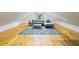 Cozy attic living room with hardwood floors, a comfortable sofa, and a large, stylish rug at 230 Pebble Trl, Alpharetta, GA 30009