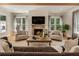 Comfortable living room with a brick fireplace, large windows, and stylish furnishings for relaxation and gatherings at 230 Pebble Trl, Alpharetta, GA 30009