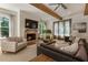 Cozy living room features a brick fireplace, wood beams, and large windows for a warm and inviting atmosphere at 230 Pebble Trl, Alpharetta, GA 30009