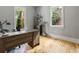 Office space featuring a wooden desk, windows with a view, and hardwood floors at 230 Pebble Trl, Alpharetta, GA 30009