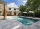 Lovely backyard pool with lounge chairs, umbrellas, and a charming two-story home in a lush, green setting at 230 Pebble Trl, Alpharetta, GA 30009