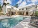 A luxurious backyard featuring a large swimming pool, lounge chairs, and covered patio at 230 Pebble Trl, Alpharetta, GA 30009