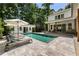 Private backyard oasis with a stunning pool, lounge chairs, and covered patio at 230 Pebble Trl, Alpharetta, GA 30009