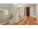 Elegant staircase featuring hardwood floors, white railings, and a rustic sliding barn door at 230 Pebble Trl, Alpharetta, GA 30009