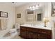 Well-lit bathroom featuring a wood vanity, white countertop, tile floors, a toilet, and a large mirror at 5155 Pine Branch Pt, Atlanta, GA 30338
