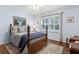 Cozy bedroom featuring a wooden bed frame, hardwood floors, and a window with natural lighting at 5155 Pine Branch Pt, Atlanta, GA 30338