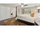Spacious bedroom featuring a four-poster bed, ceiling fan, hardwood floors, and a window for natural light at 5155 Pine Branch Pt, Atlanta, GA 30338