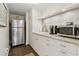 Basement kitchenette featuring stainless steel refrigerator, tile backsplash, countertops, and white cabinets at 5155 Pine Branch Pt, Atlanta, GA 30338