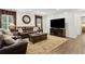 Inviting living room with brown leather sofas, hardwood floors, recessed lighting, and a large window at 5155 Pine Branch Pt, Atlanta, GA 30338