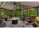 Cozy screened-in porch with stone fireplace and comfortable seating at 5155 Pine Branch Pt, Atlanta, GA 30338