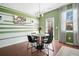 Bright dining area with a modern chandelier, table for four, and cheerful green-and-white striped accent wall at 3016 Creekside Overlook Way, Austell, GA 30168