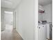 Hallway laundry area with a white washer and dryer, storage shelves, and white walls at 3016 Creekside Overlook Way, Austell, GA 30168