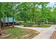 Long driveway leading to a charming cottage-style home nestled among mature trees and lush greenery at 5419 Tyree Rd, Winston, GA 30187