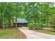 Scenic long driveway winding through mature trees, leading to a red home with a metal roof at 5419 Tyree Rd, Winston, GA 30187