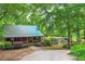 Exterior view of the cottage-style house with a metal roof, rv parking, and surrounding mature trees at 5419 Tyree Rd, Winston, GA 30187