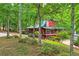 Secluded cottage-style home nestled among lush trees, with a stone chimney and covered porches at 5419 Tyree Rd, Winston, GA 30187