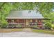 Charming cottage-style home with a metal roof, inviting front porch and attractive landscaping at 5419 Tyree Rd, Winston, GA 30187