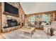 Living room features stone fireplace, wood paneling, hardwood floors, and plenty of natural light at 5419 Tyree Rd, Winston, GA 30187