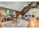 Living room featuring hardwood floors, stone fireplace, wood paneling, and staircase at 5419 Tyree Rd, Winston, GA 30187