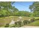 Scenic view of a pond with a fountain, a dock, and lush greenery, creating a serene and picturesque landscape at 5419 Tyree Rd, Winston, GA 30187