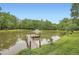 Exterior of a charming pond with a dock and fountain, surrounded by lush trees for a peaceful outdoor retreat at 5419 Tyree Rd, Winston, GA 30187